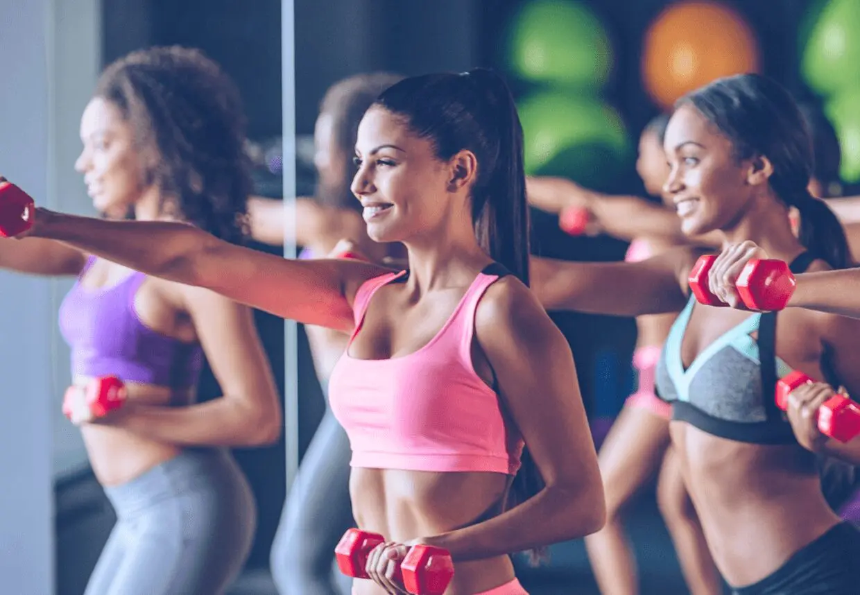13 Women exercising with dumbbells in fitness class.